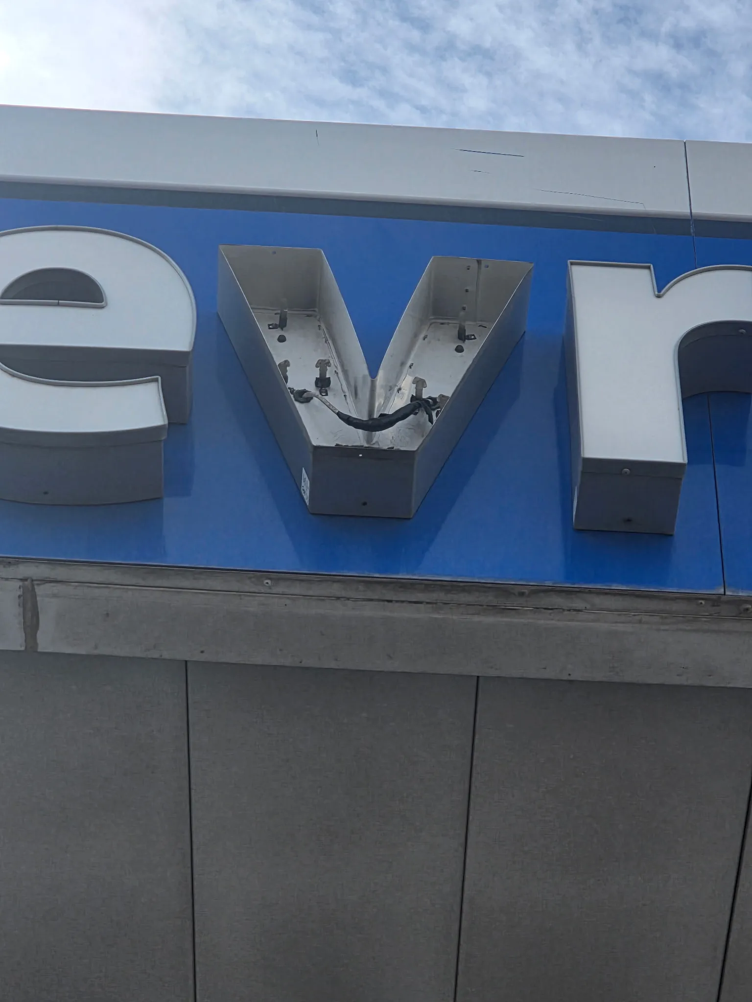 Close-up of a channel-letter sign opened up, internal LED modules and wiring exposed for repair